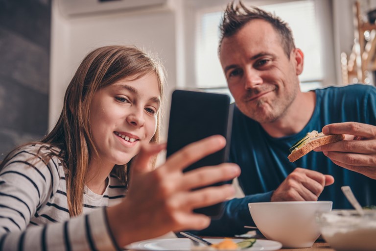Dad and daughter looking at mobile phone