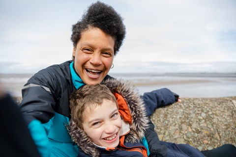 Woman and boy laughing on beach
